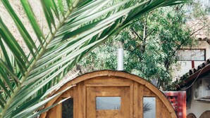 Una estructura de madera con forma circular, que incluye una puerta con paneles de vidrio y un ventanal pequeño.