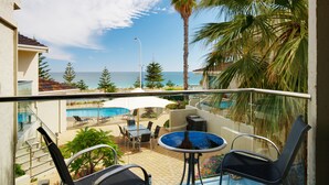 A balcony with a pool table, chairs, and a view of the sea. - Seashells Scarborough (Scarborough)