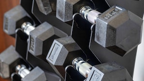 A rack of hexagonal dumbbells with weight labels, arranged in a vertical line. - Best Western Plus Hotel Papenburg (Papenburg)