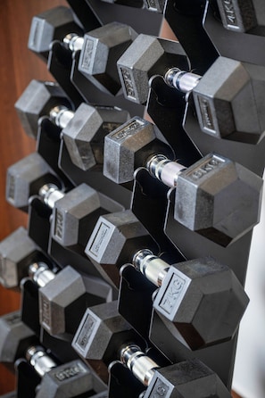 A rack of hexagonal dumbbells with weight labels, arranged in a vertical line. - Best Western Plus Hotel Papenburg (Papenburg)