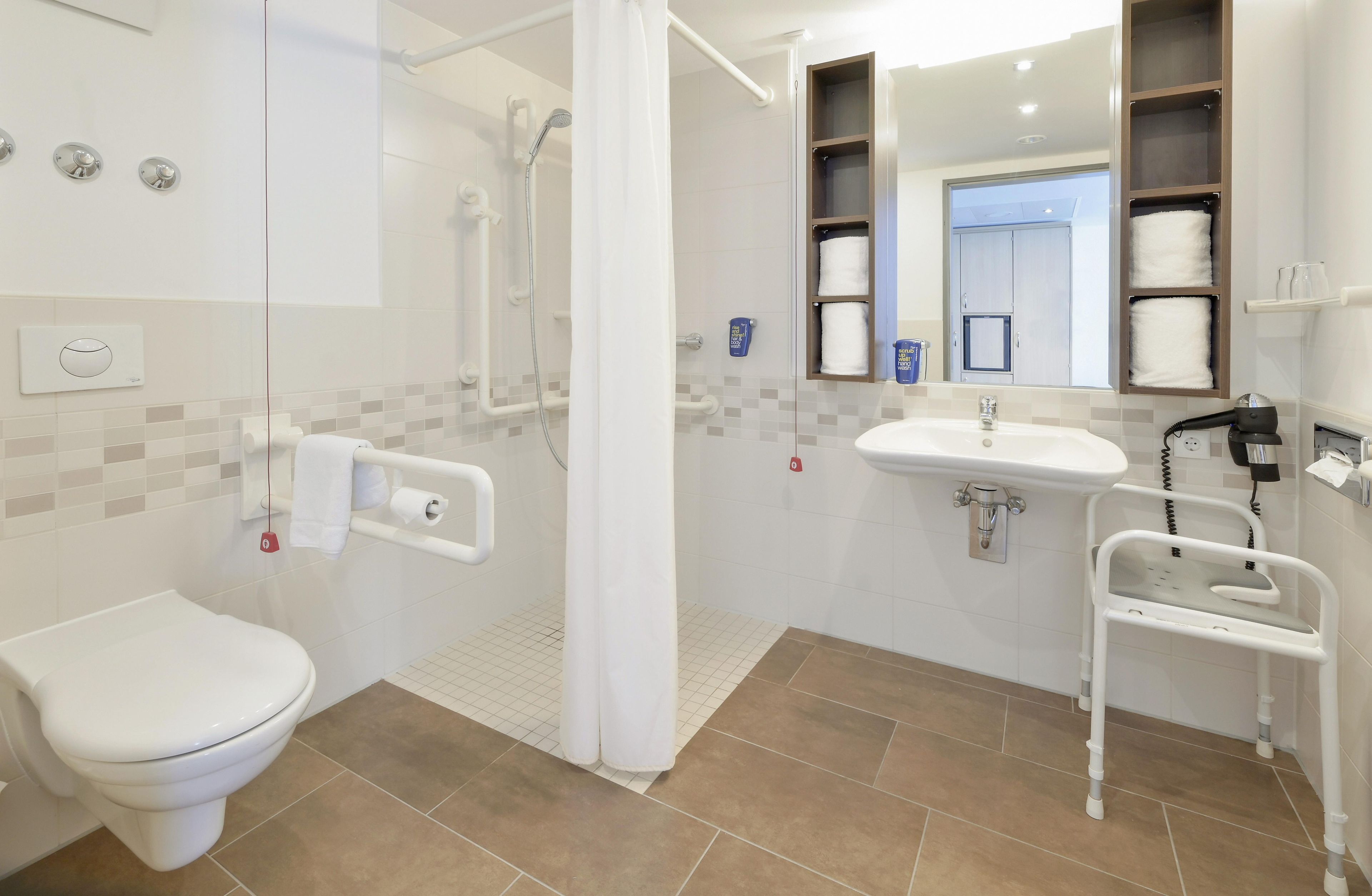 Ein modernes Badezimmer mit Toilette, Waschbecken, Dusche und einer gläsernen Duschkabine.