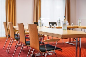 A conference room with a long table, several chairs, and water bottles on the table. - Best Western Plus Hotel Papenburg (Papenburg)