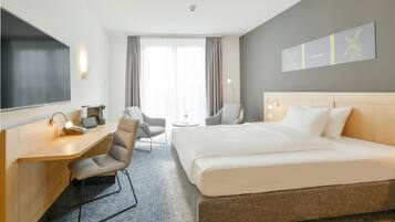 Une chambre d’hôtel équipée d’un lit, d’un bureau, d’une chaise et d’un téléviseur.