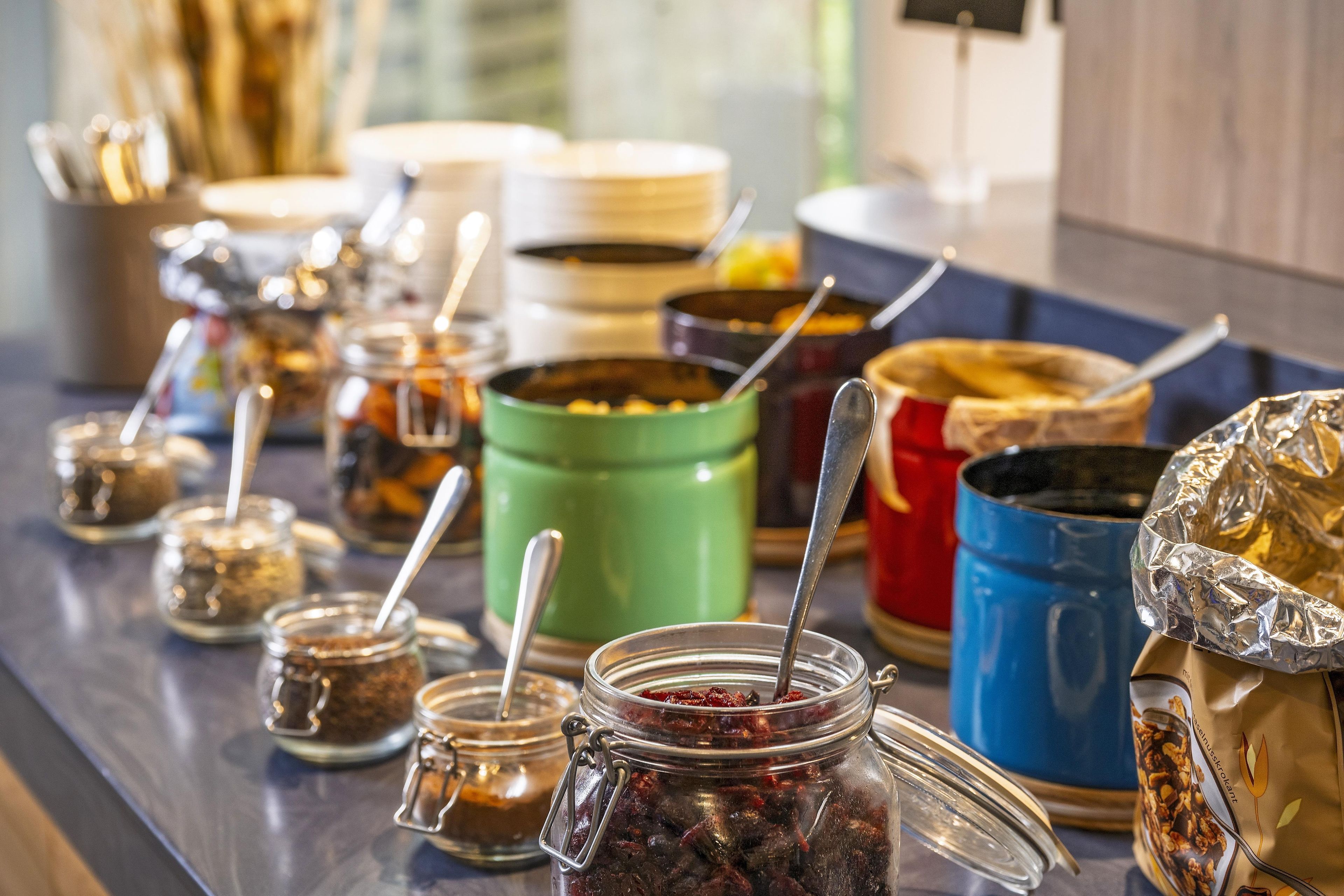 A buffet table with various food containers and utensils.