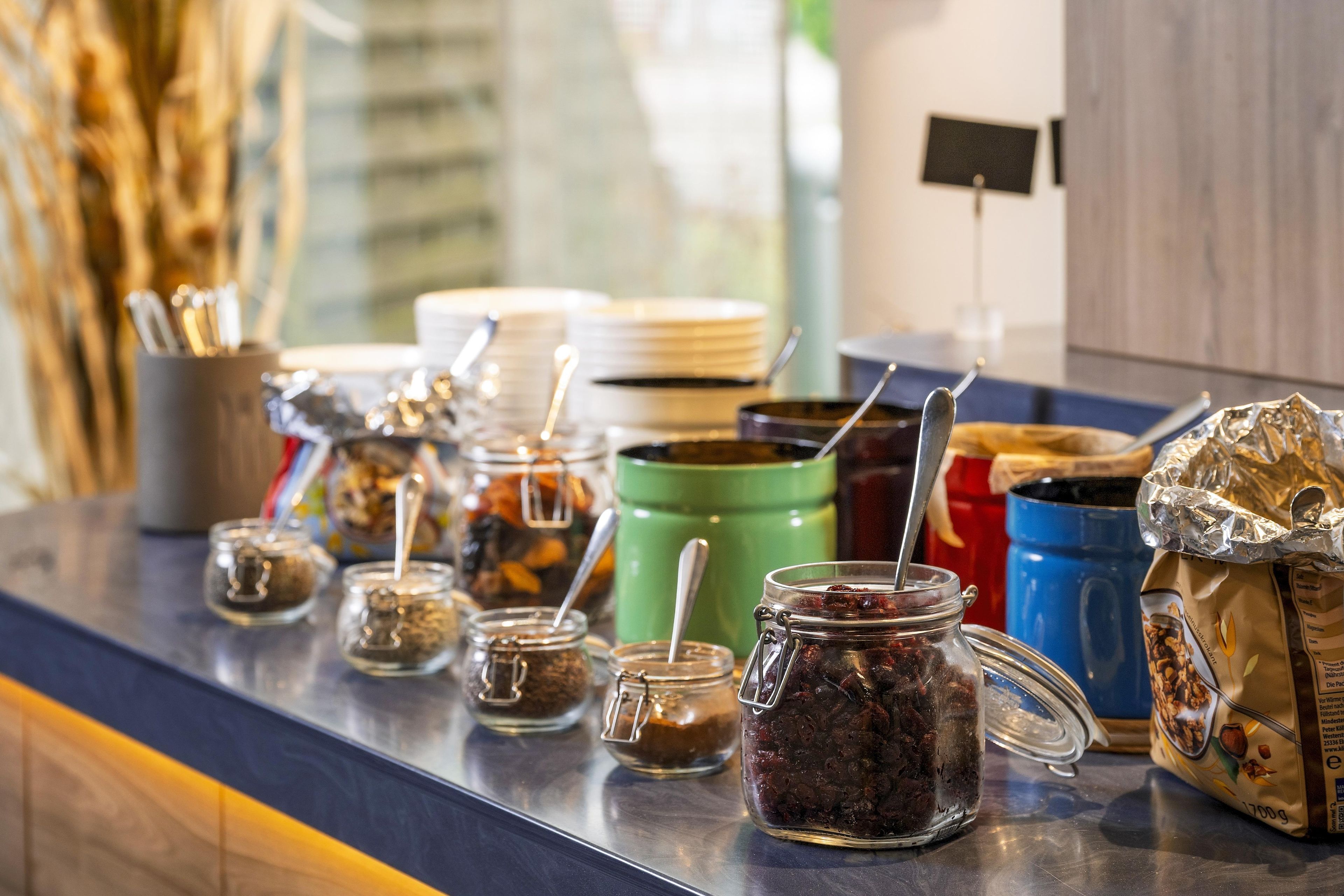 Mostrador de buffet con diversos alimentos y utensilios.