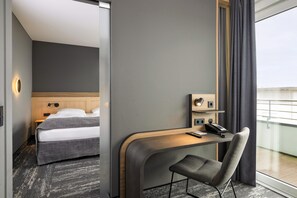 A hotel room with a bed, a desk with a chair, a phone, and a window with curtains. - Best Western Plus Hotel Papenburg (Papenburg)