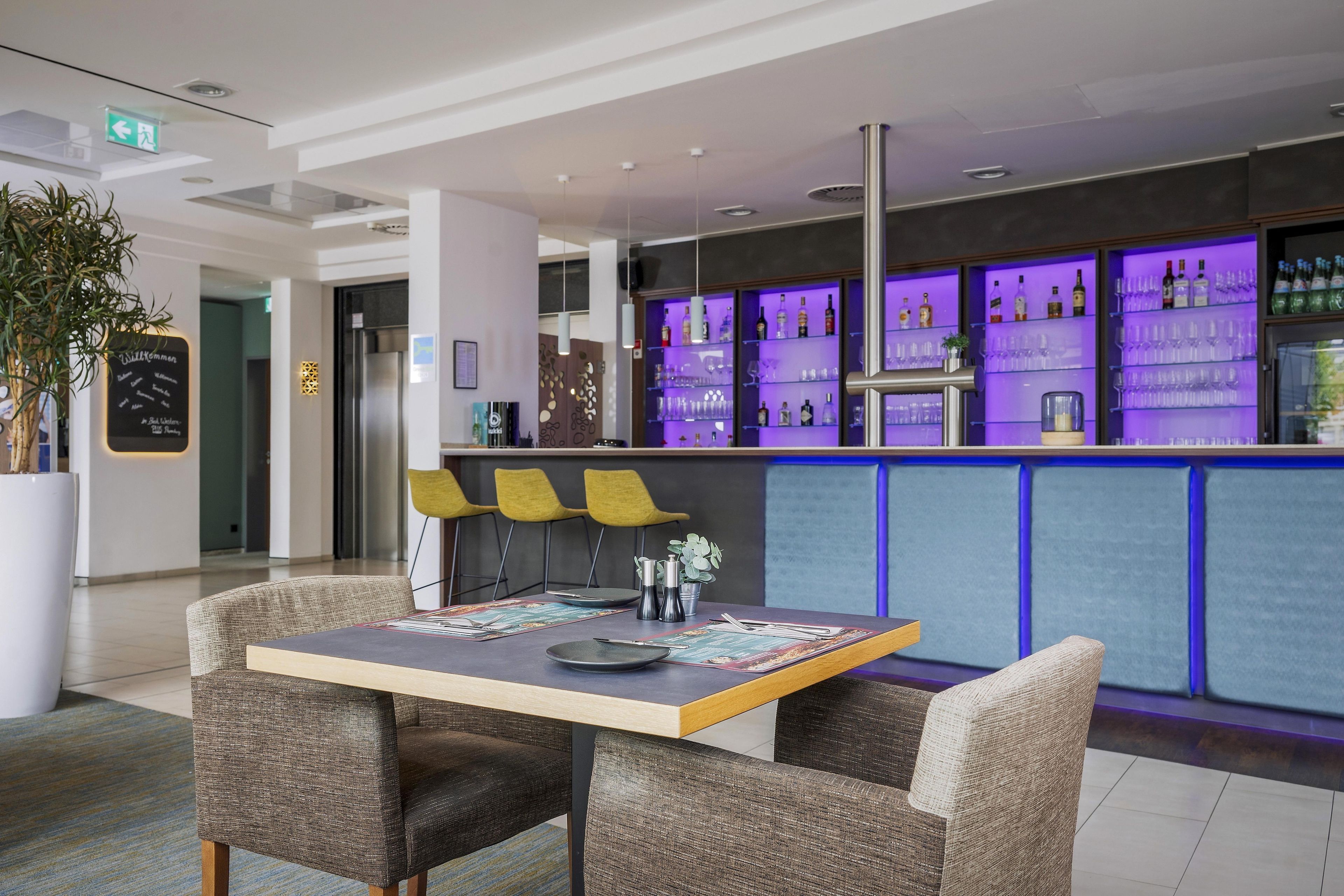 Eine moderne Bar mit Sitzgelegenheiten und einer Flaschenauslage.