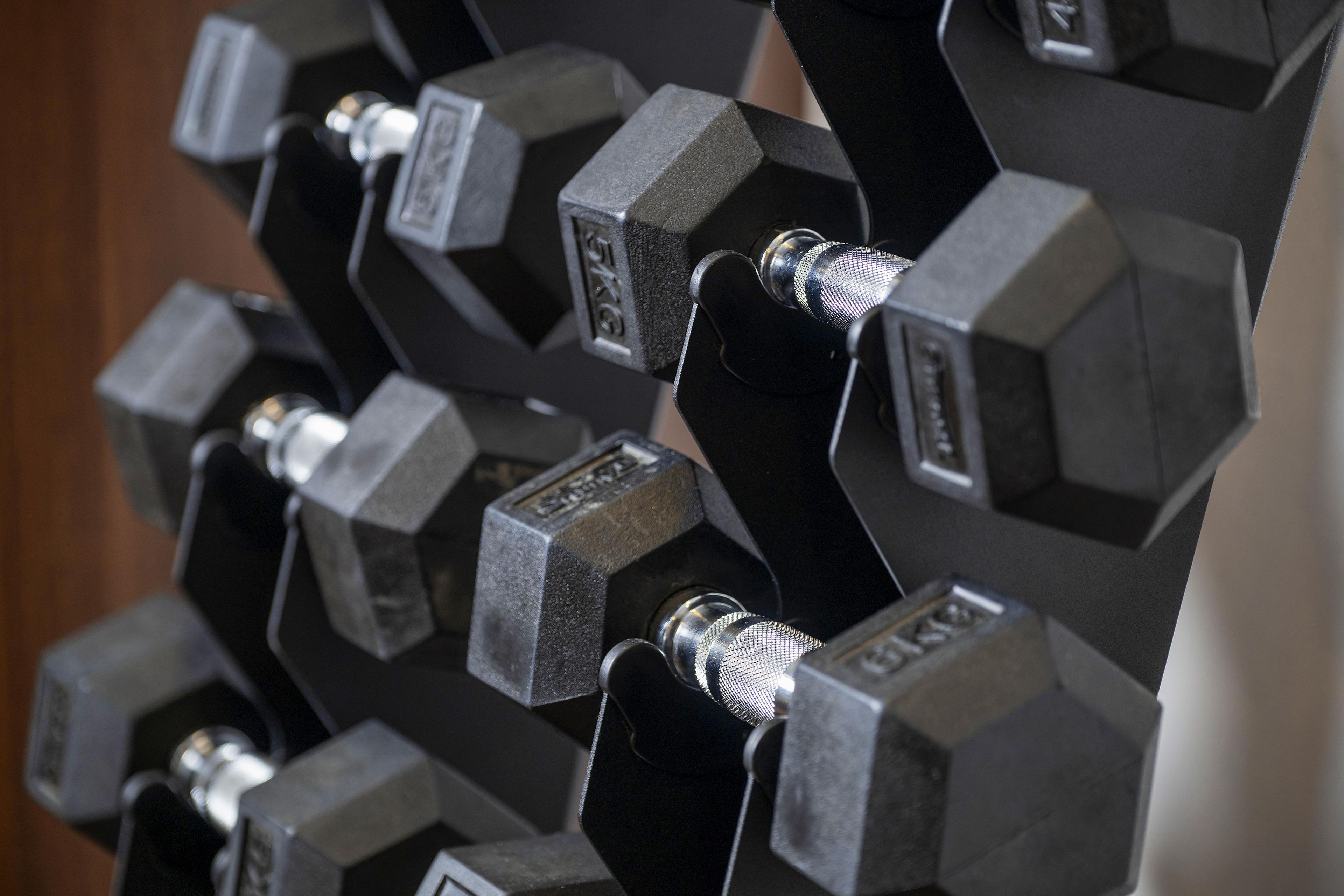 A close-up of a set of hexagonal dumbbells with visible weight markings.