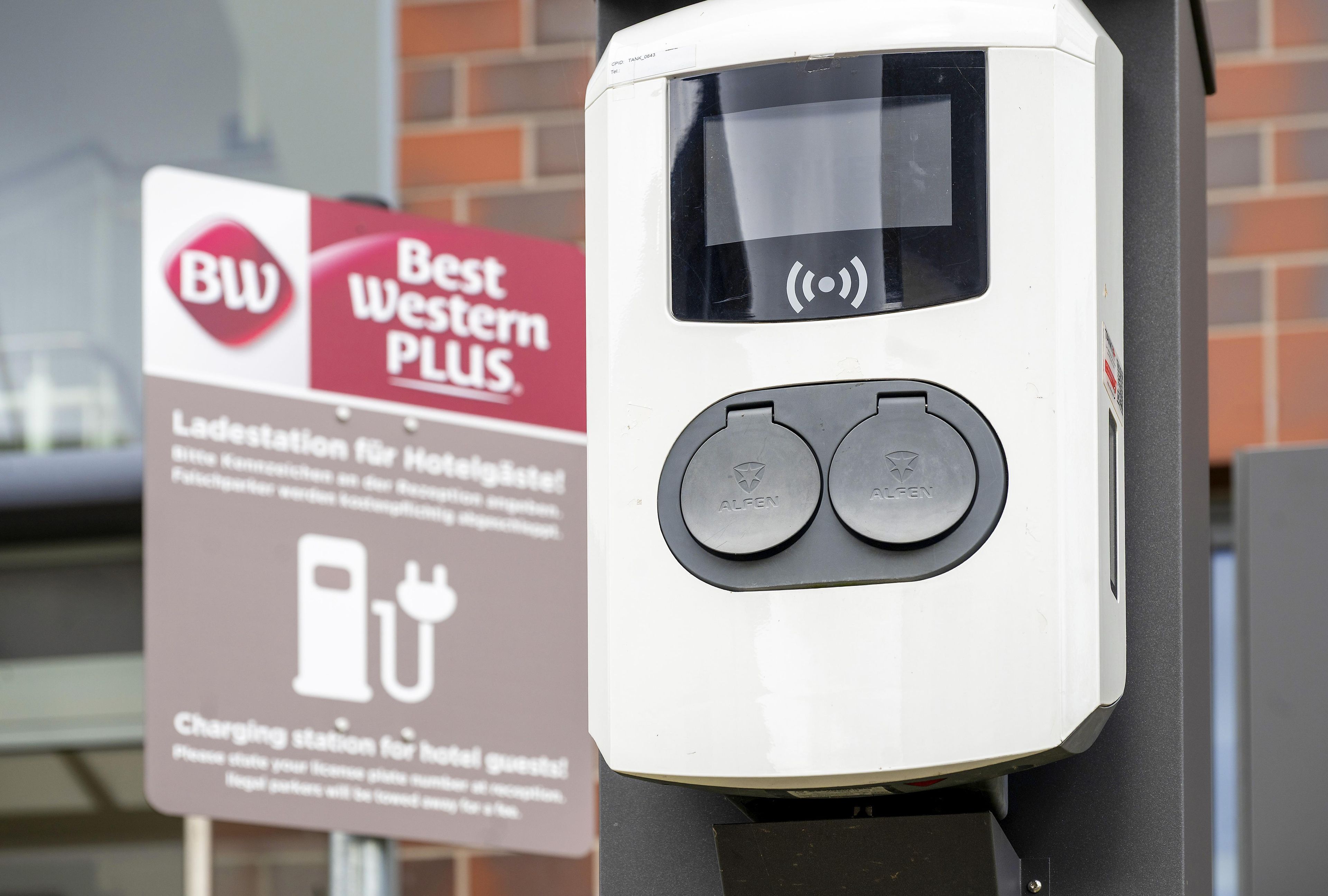 Een oplaadstation met twee ronde knoppen met de tekst 'ALFEN' voor elektrische voertuigen.