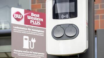 Een oplaadstation met twee ronde knoppen met de tekst 'ALFEN' voor elektrische voertuigen.