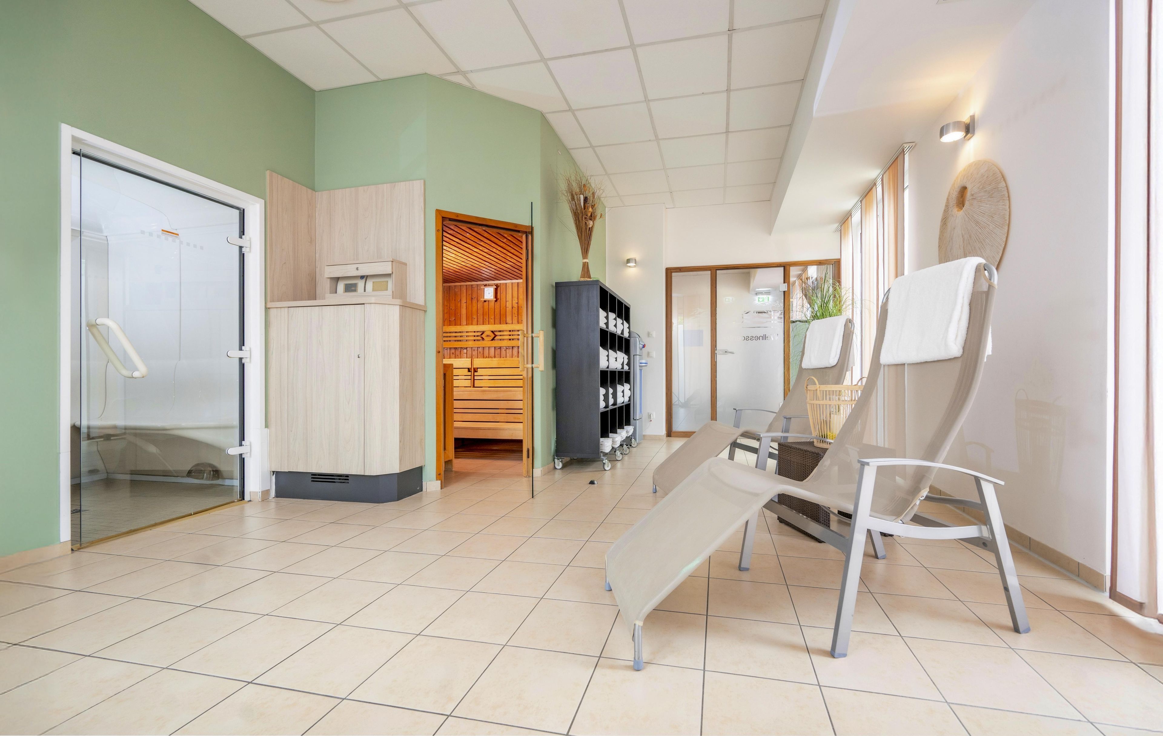 Ruime kamer met tegels op de vloer, een houten kast, een bankje en een wandplank met spullen.