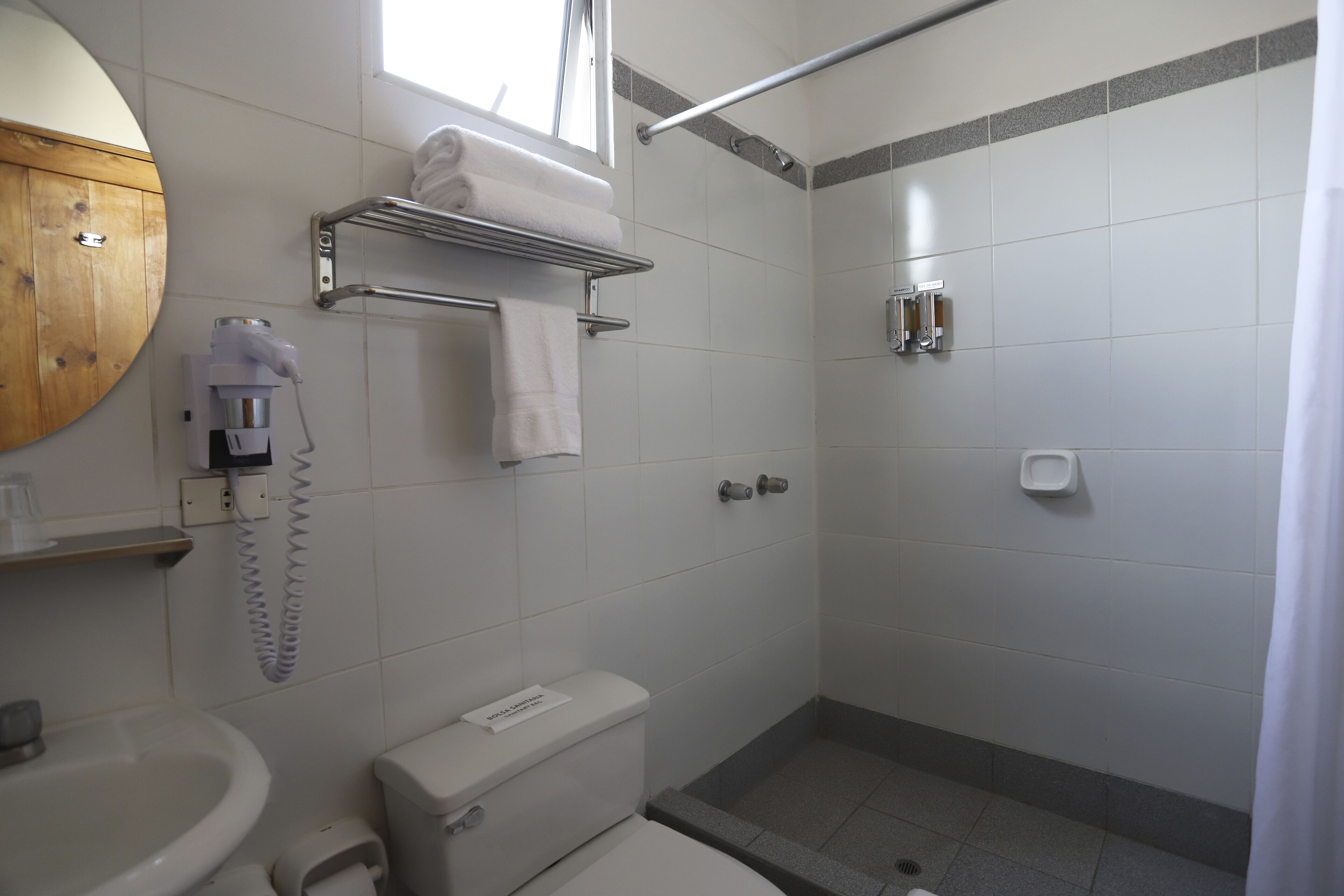 Une salle de bain équipée de toilettes, d’un lavabo, d’une douche et d’un porte-serviettes.