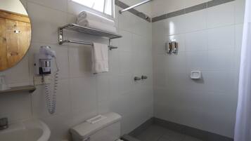 Ein Badezimmer mit Toilette, Waschbecken, Dusche und Handtuchhalter.