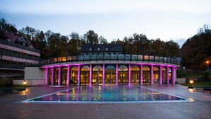 A building with a pool, large windows, and a balcony. - Hôtel & SPA Les Violettes (Soultz-Haut-Rhin)