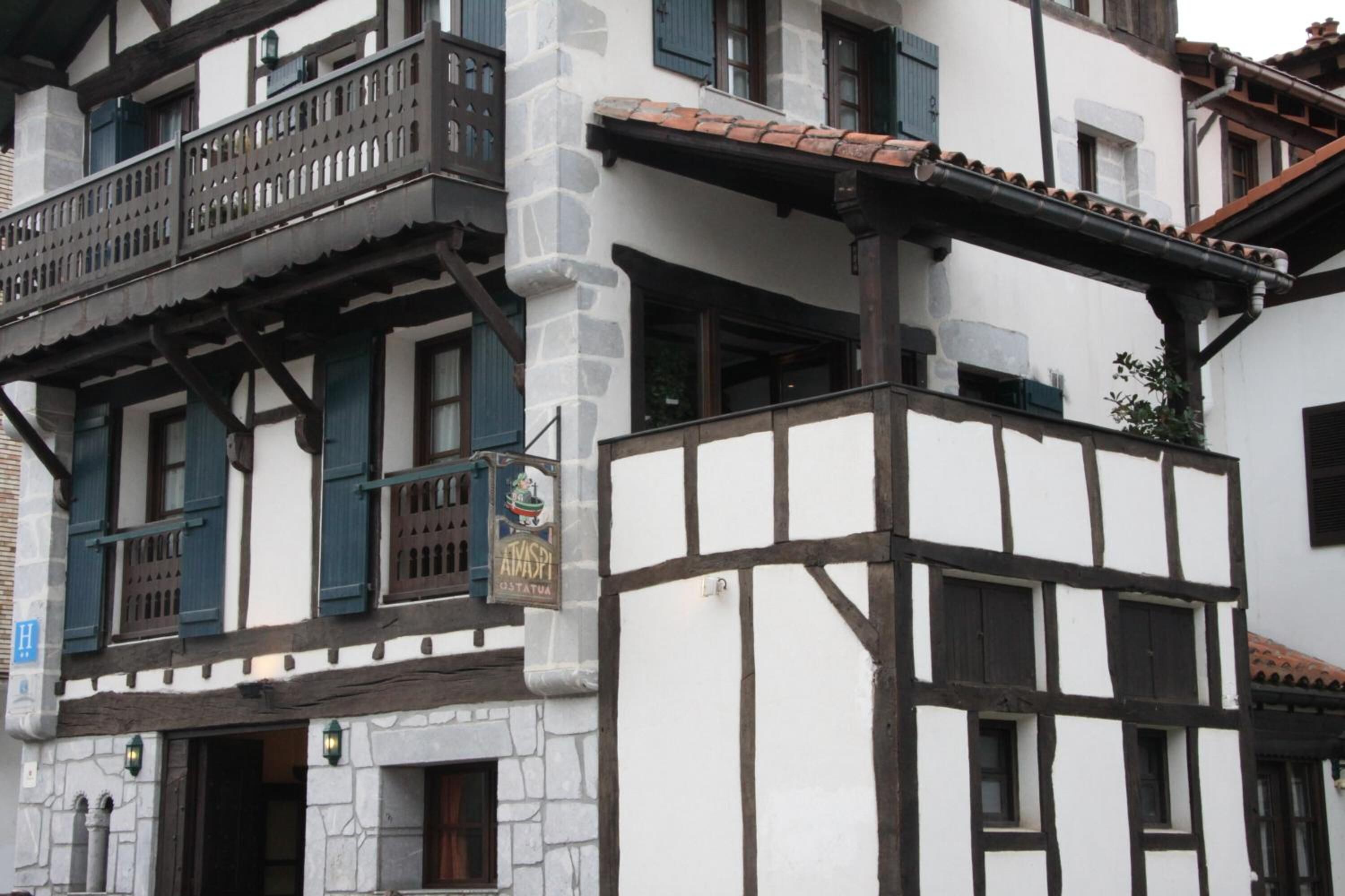A traditional half-timbered building with a balcony and a sign indicating a restaurant.