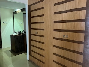 A hallway with a wooden wardrobe featuring horizontal slats and two silver handles. - Palette Torre Venezia Suites (Quezon City)