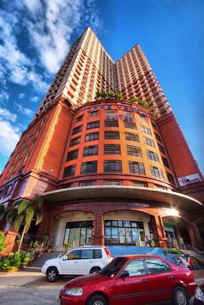 A tall hotel with a curved facade, balconies, and a sign reading "TORRE VENEZIA SUITES". - Palette Torre Venezia Suites (Quezon City)