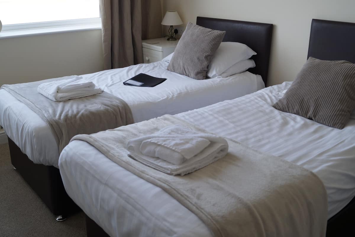 Habitación con 2 camas individuales, baño privado | Escritorio, tabla de planchar con plancha, wifi gratis y ropa de cama