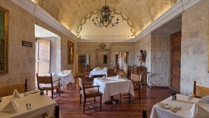 A dining area with tables set for service, a chandelier, and a mirror on the wall. - Casa Andina Premium Arequipa (Arequipa)