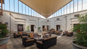 A spacious indoor courtyard with wicker furniture, potted plants, and a large open area. - Casa Andina Premium Arequipa (Arequipa)