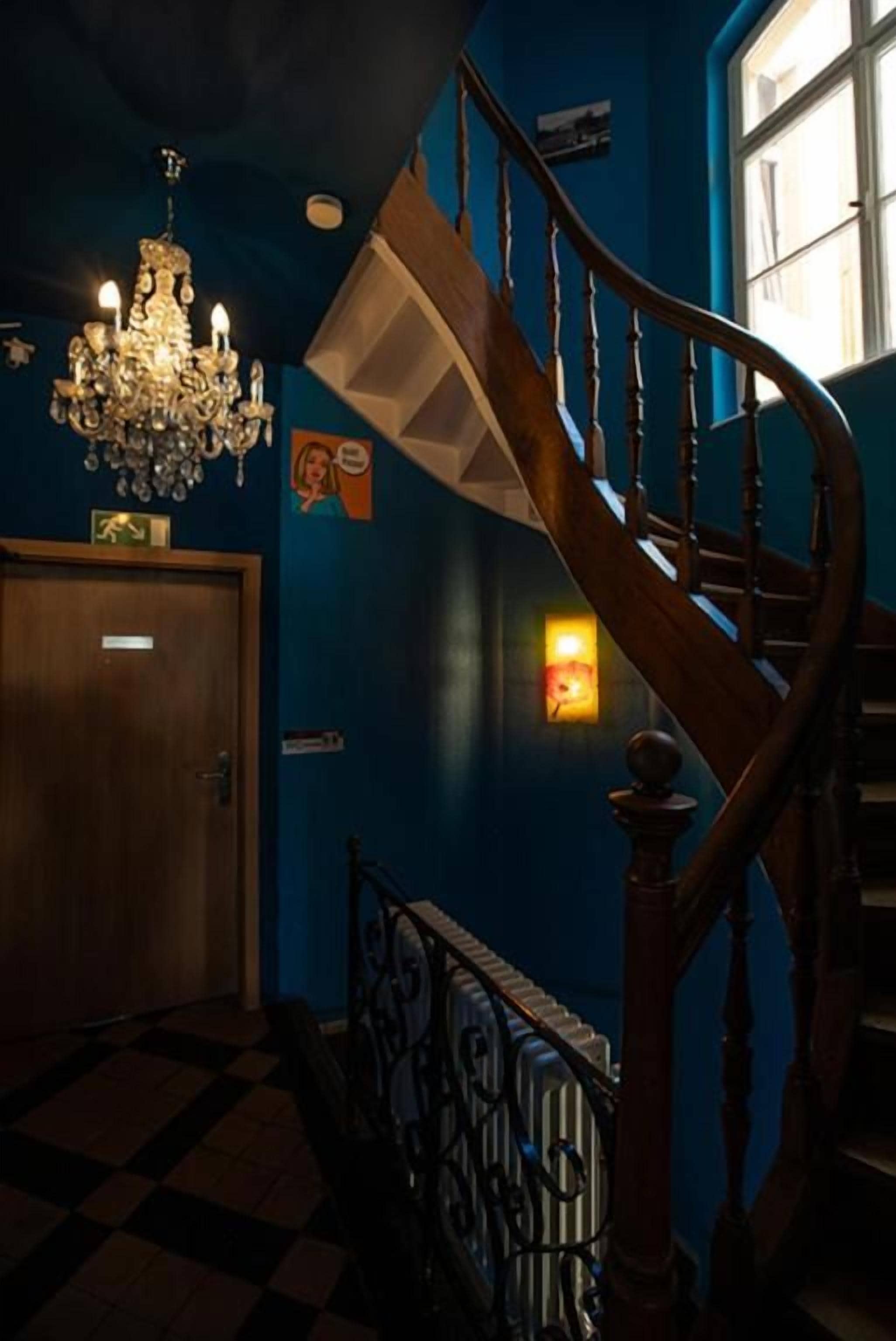 Un escalier avec une rampe en bois et un lustre.