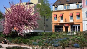 A building with a red awning and a sign that reads "Restaurant." - Hotel Rosengarten Kehl (Kehl)
