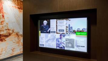 Ein digitales Display in der Hotelhalle mit verschiedenen Nachrichten und Reiseinformationen.