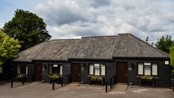 A wooden building with a sloped roof, multiple doors, and windows.
