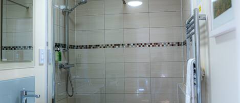 A bathroom with a shower, sink, and mirror.