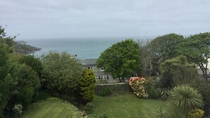 A coastal view with a grassy area, trees, and a distant sea. - Borthalan Hotel (St Ives)