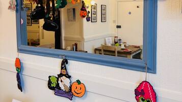 A mirror with Halloween decorations including a pumpkin, a ghost, and a character with a knife.