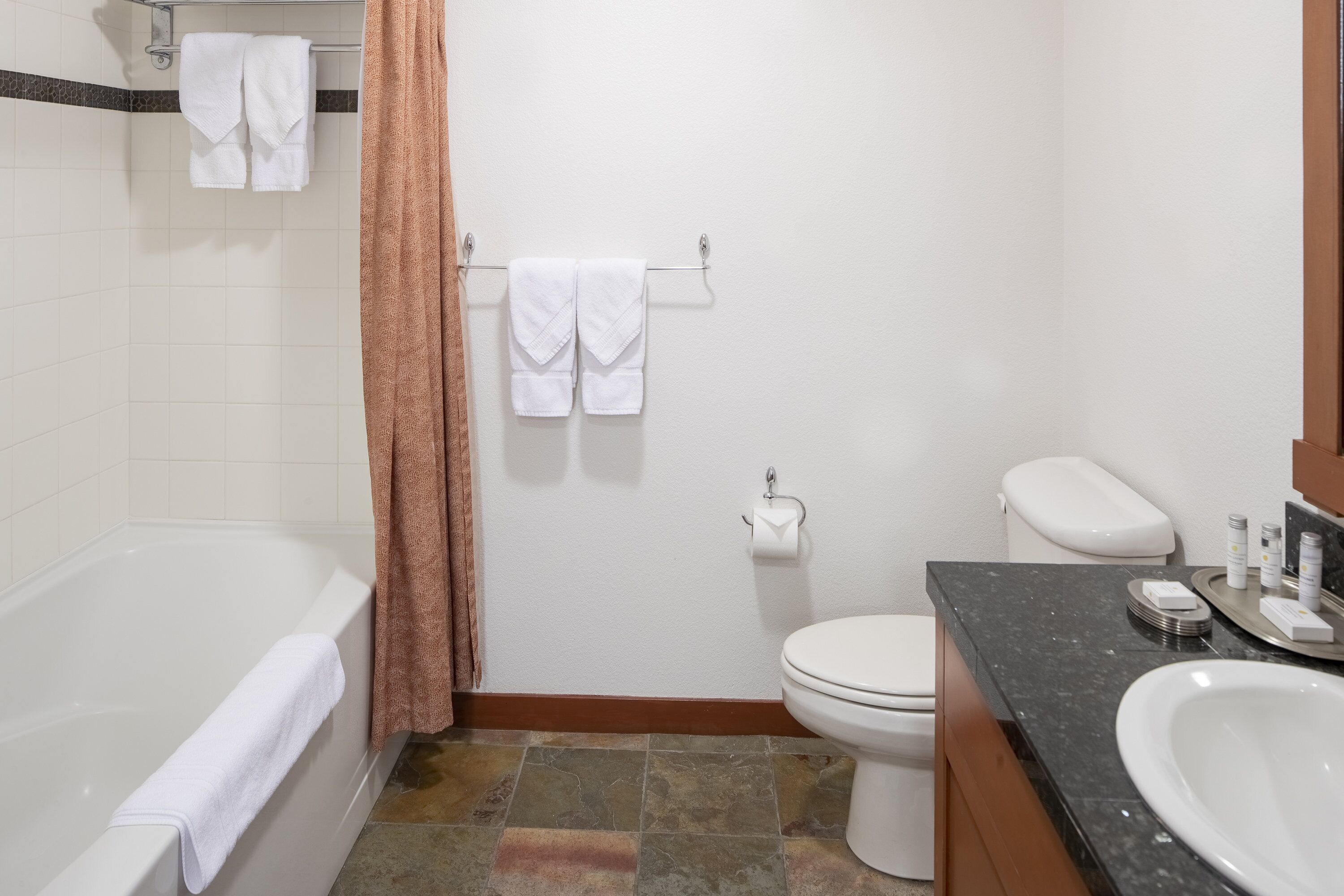 A bathroom with a bathtub, toilet, and sink.