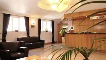 A reception area with a wooden reception desk, a sofa, and a coffee table.