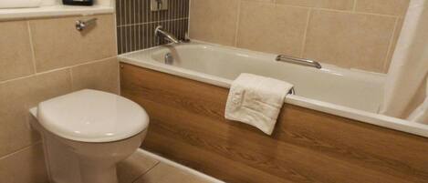 A bathroom with a toilet, a bathtub, and a shower.