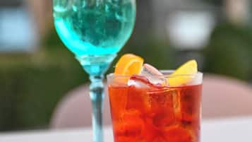Deux cocktails sur une table, avec un arrière-plan flou représentant un décor extérieur.