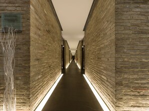 Un long couloir étroit aux murs de briques, avec une pancarte indiquant l’emplacement de la réception et de la salle de petit-déjeuner.