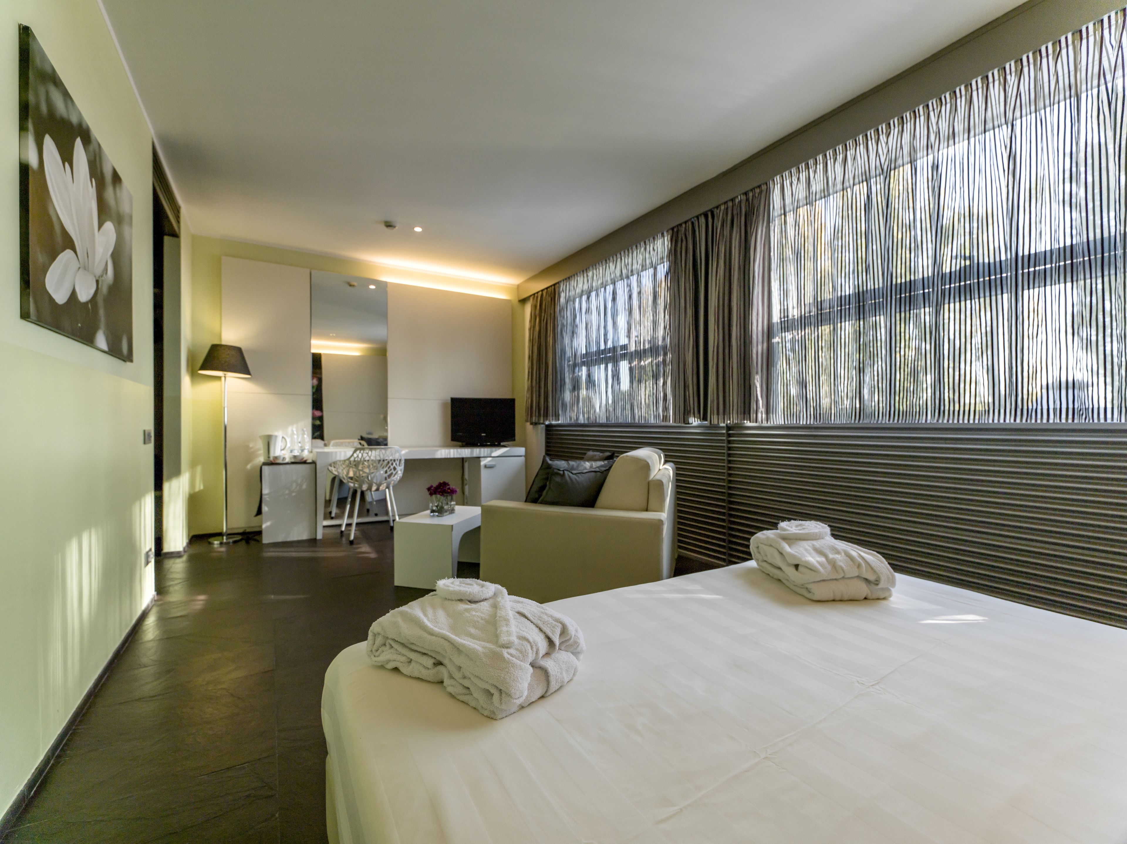 Une chambre d’hôtel avec un lit, un bureau, une chaise et un téléviseur.
