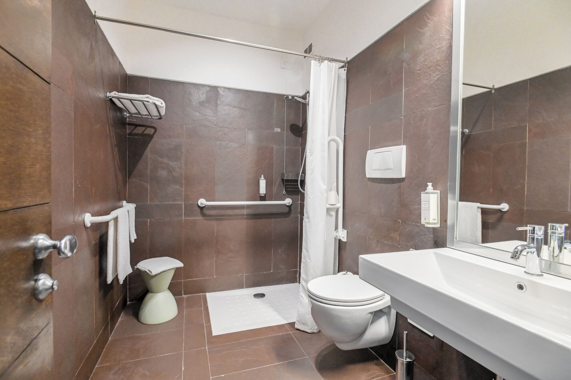 Un bagno moderno dotato di doccia, toilette e lavabo.
