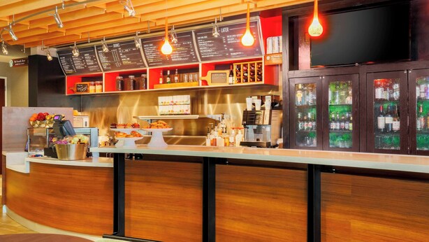 Eine Bar mit Holztresen, Speisekarten und einer Getränkeauslage.