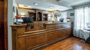 A kitchen with wooden cabinetry, a built-in island, and a window with curtains.