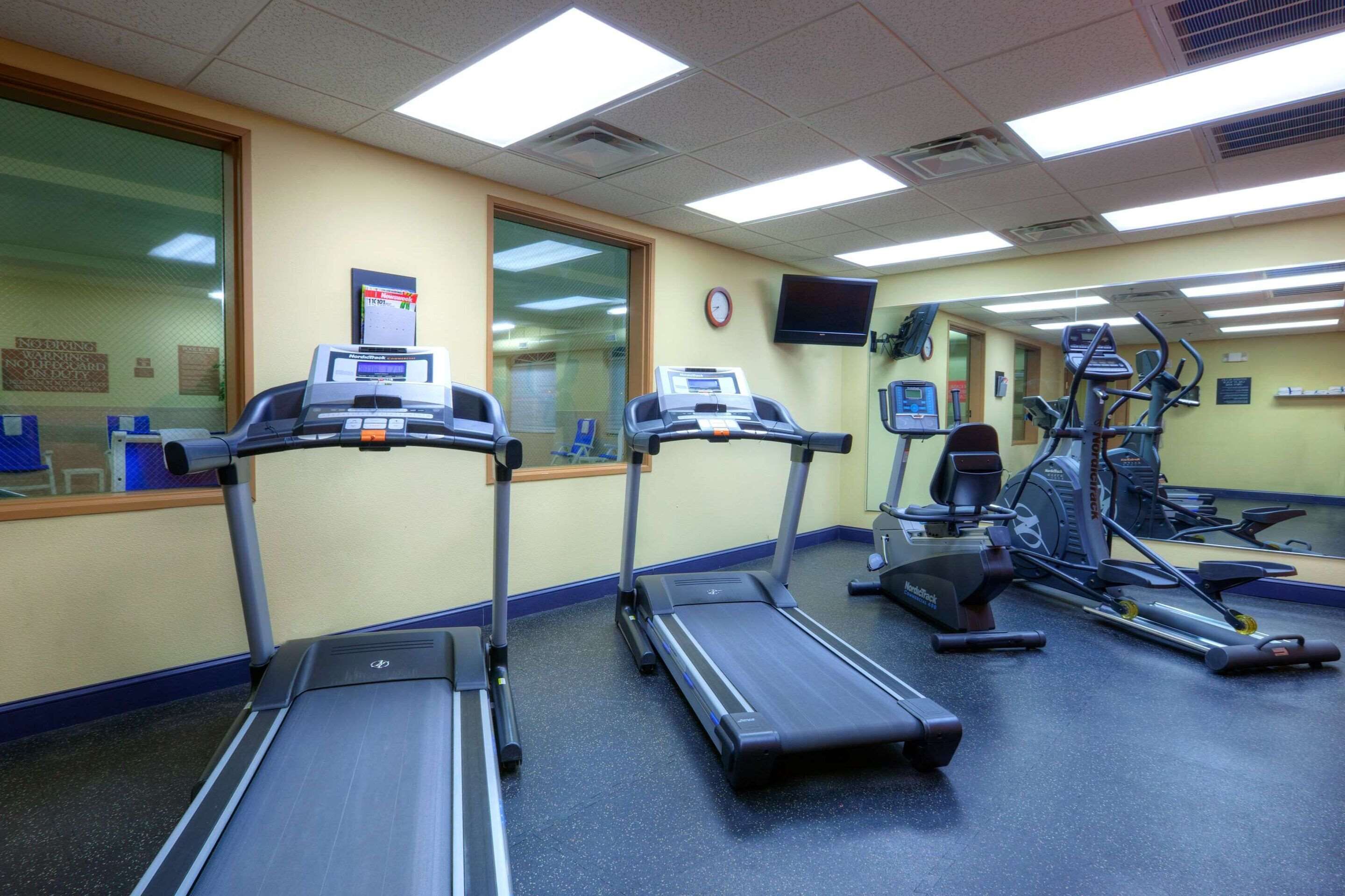 A fitness center with treadmills, elliptical machines, and a stationary bike.