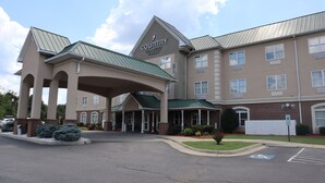 A Country Inn & Suites by Radisson building with a covered entrance, multiple windows, and a parking lot with handicapped accessibility.