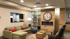 A modern living room with a sofa, a coffee table, and a TV mounted on a wooden wall.