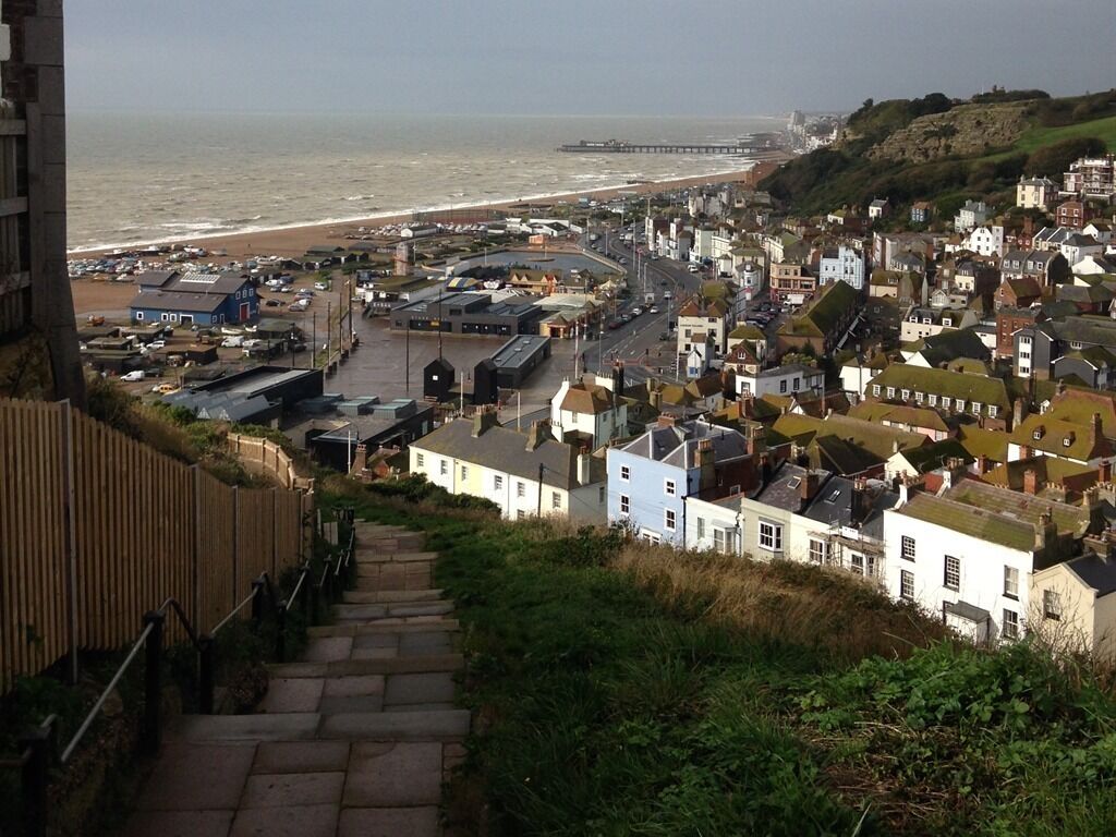 A coastal town with a prominent pier, a beach, and a mix of residential and commercial buildings.