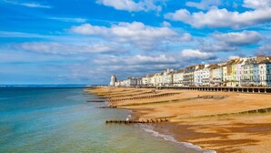 A coastal town with a long promenade, colorful buildings, and a clear sky. - Hastings House (St Leonards-On-Sea)