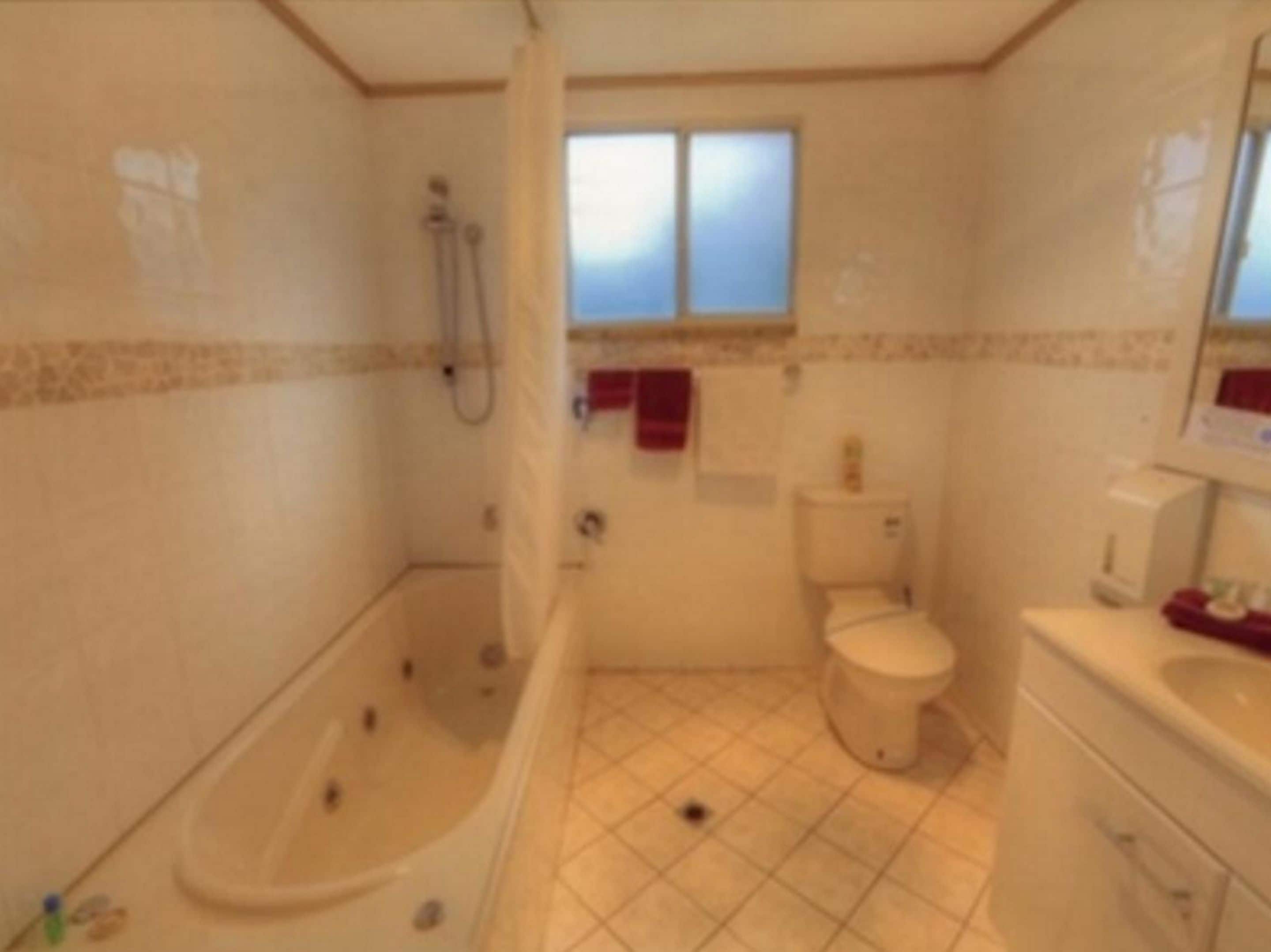 Ein kleines Badezimmer mit Fliesen, ausgestattet mit Badewanne, Toilette und Waschbecken.