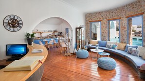 Ein modernes Wohnzimmer mit Holzboden, einem großen Sofa und Meerblick.