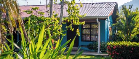 A house with a metal roof, surrounded by lush greenery and a well-maintained garden.