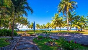 A pathway leading to a beach with palm trees and a clear view of the ocean. - Beach Break Resort (Jacó)