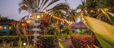 A signpost with multiple directions including reception, tour office, and beach.